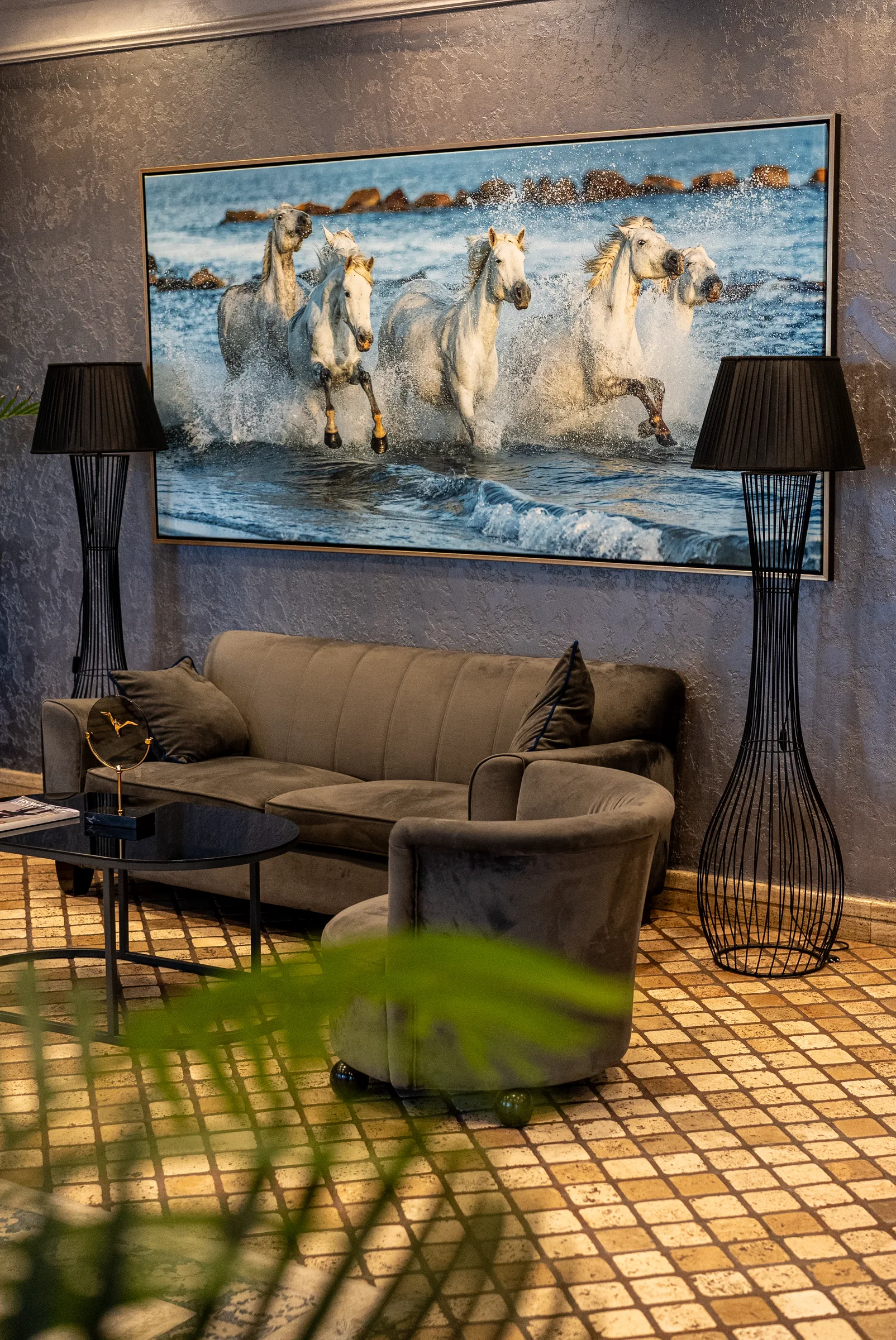 Otel lobisi — at temalı tablo ve kadife koltuklar