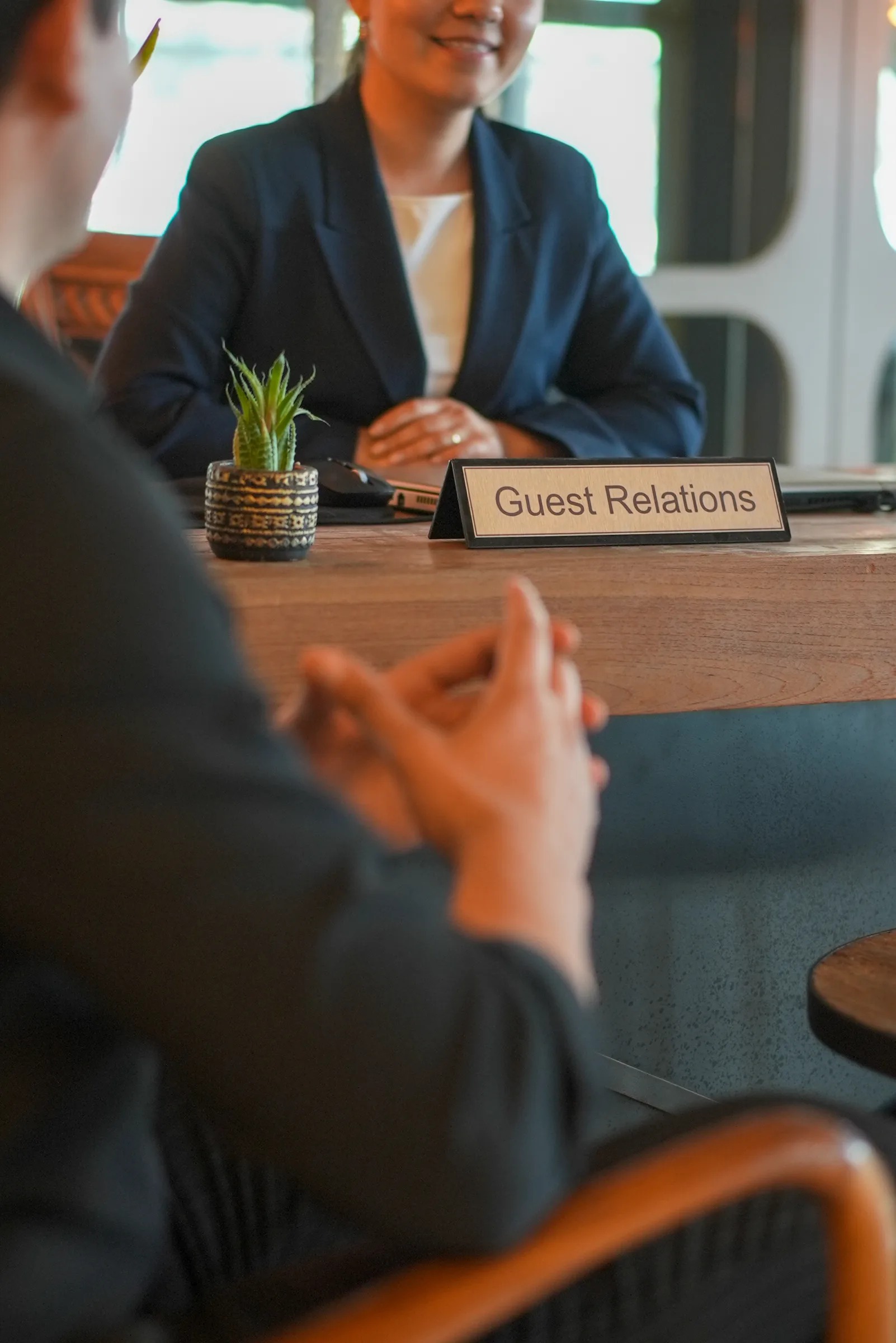 Guest Relations bankosunda konuğu karşılayan otel çalışanı